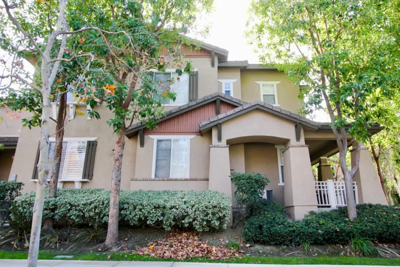 A view of the two story structure with plenty of windows and mature trees at Chambray in Ladera Ranch, California