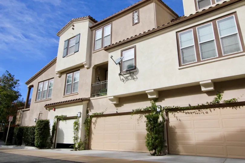 Traditional three-storey townhouses in the Sansovino community with climbing vines in the garages.