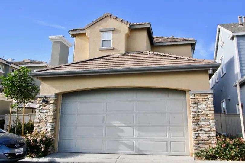 A tan home with stone around the garage door in St. Mays Road community in Ladera Ranch, California.