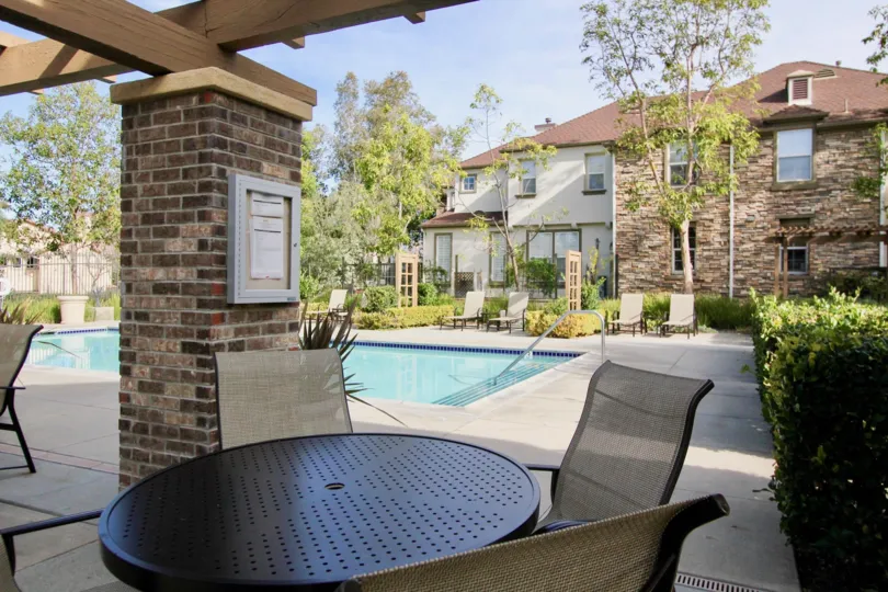 A sunny day in the area of Sycamore Grove, poolside, chair, patio, condo, bushes, stairs