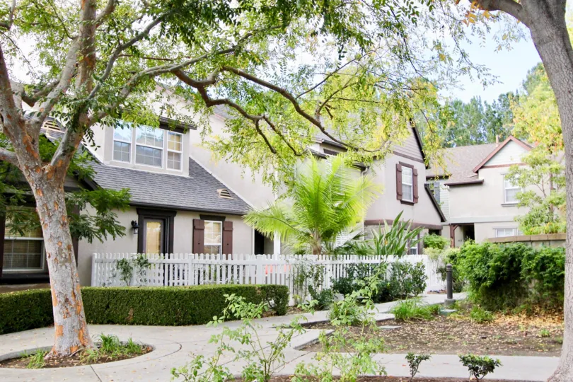 Gorgeous view of residences in Three Vines in Ladera Ranch, California. Residences are surrounded with luscious foliage from trees and bushes along pathways to the homes.