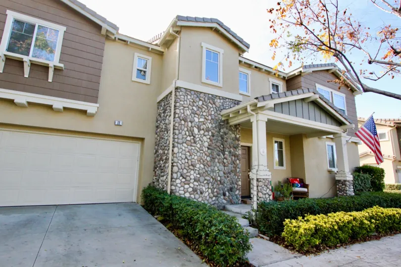 A Big villa with plants in front and USA Flag of Valmont of Ladera Ranch