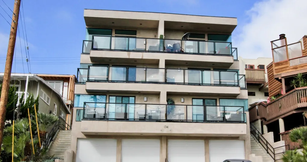 A bright day in the 174 Cliff Drive with a building and glass balcony.