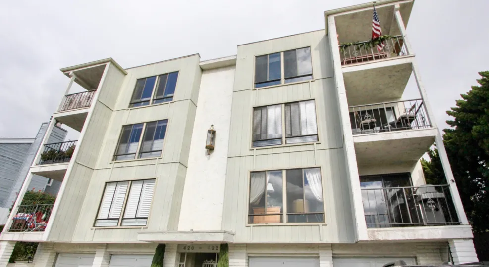 THE 420-432 APARTMENTS IN THE LAGUNA NORTH SHORES WITH THE BALCONIS, PLANTS, TREES, FLAG