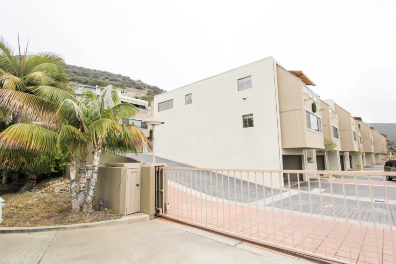 A driveway lined with pink bricks behind a security fence at Laguna Ocean Vista in Laguna Beach CA