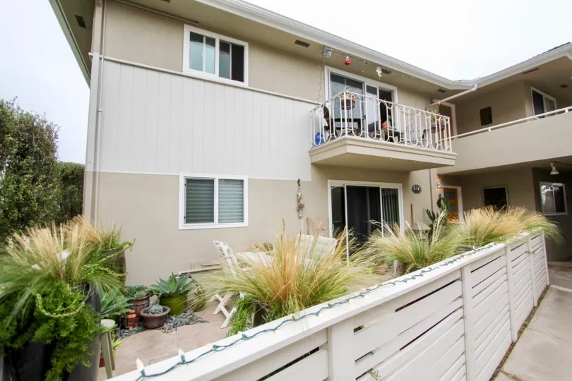 Cloudy sky with a building and a balcony and fence in Ocean Vista Community in Laguna Beach, CA.