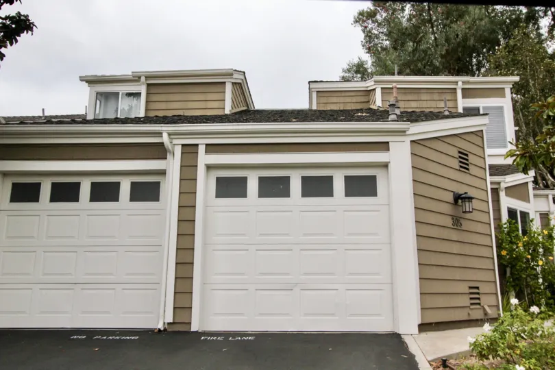 Cloudy sky with garages and a tree in the Terraces at Canyon Hills Community in Laguna Beach, CA.