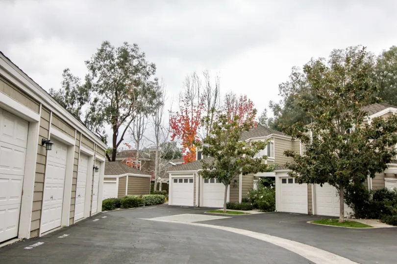 Cloudy sky with apartments and garages and trees in the Terraces at Canyon Hills Community in the Laguna Beach, CA.