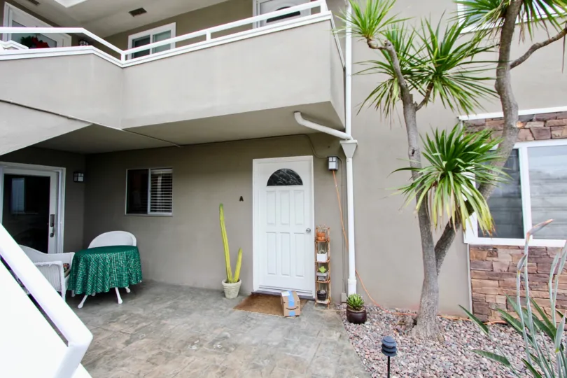 THE BUILDING IN THE WESLEY PACIFIC WITH THE PLANTS, TREES, TABLES, BALCONIS