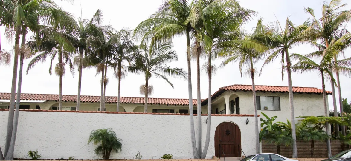 a warm day in the woods cove with a building with roofless top and many coconut trees in front