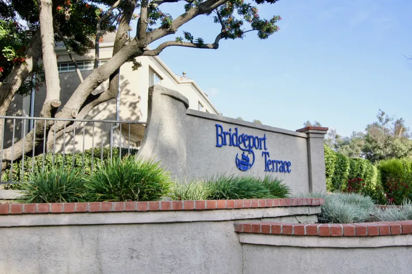 entrance to the Bridgeport terrace rental community with trees and bushes