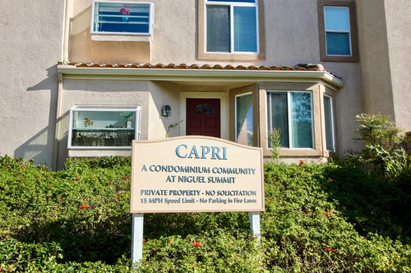 a sunny day in the capri with a building which has name board of its community in front