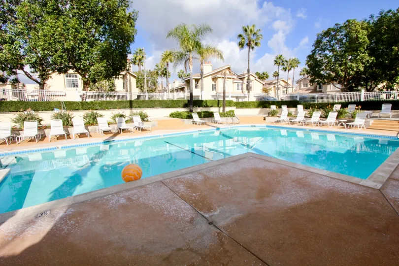 L shape swimming pool with ball and relaxing chairs in Del Prado.