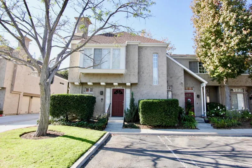 An old model house is located Hampton Village with brown doors.