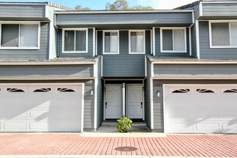 Front of 2 adjoining wooden houses with garages in Laguna Niguel, Marin County