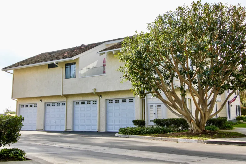 a sunny day in the sparrow hill with a house that has closed parking door in front of it with roofless top and has a balcony too
