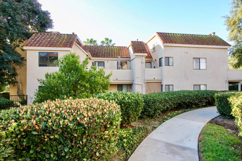 A beautiful white-walled house with a gorgeous lawn and nicely paved pathway