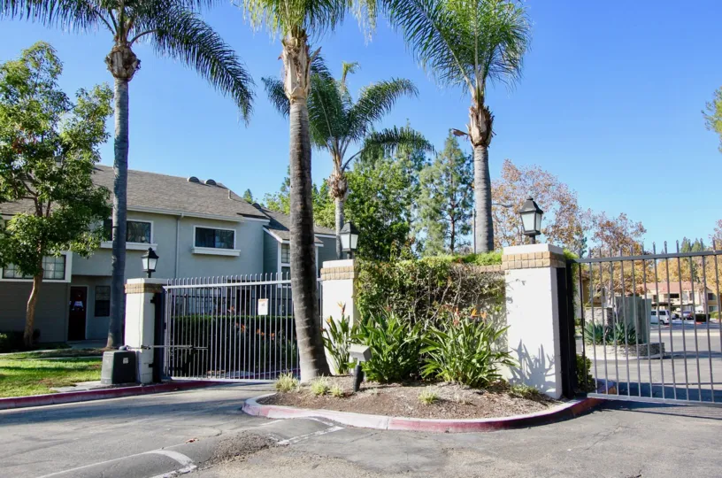 There are some palms trees nearby a building in the Village Niguel Terrace I neighborhood of CA.