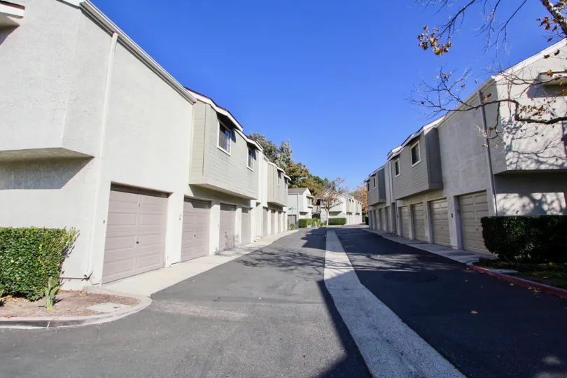 a sunny day in the village niguel terrace l with a road that has white line in front with similiar buildings on the either side