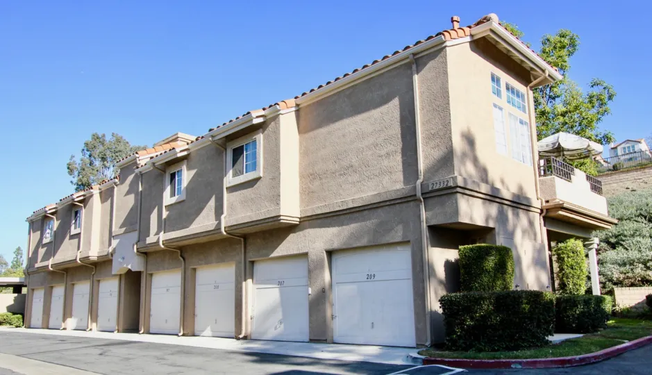 A building is situated nearby the road in the Village Niguel Terrace II.