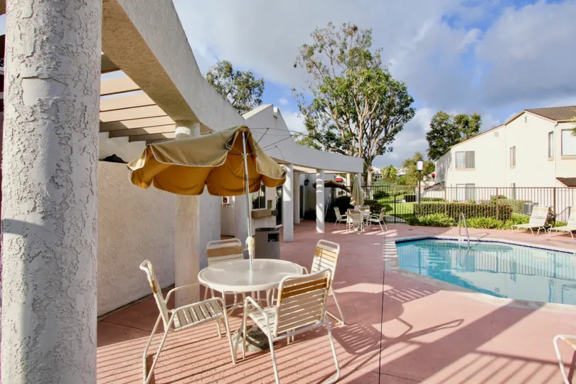 A table surrounded by chairs nearby swimming pool in the Vista Del Cerro.