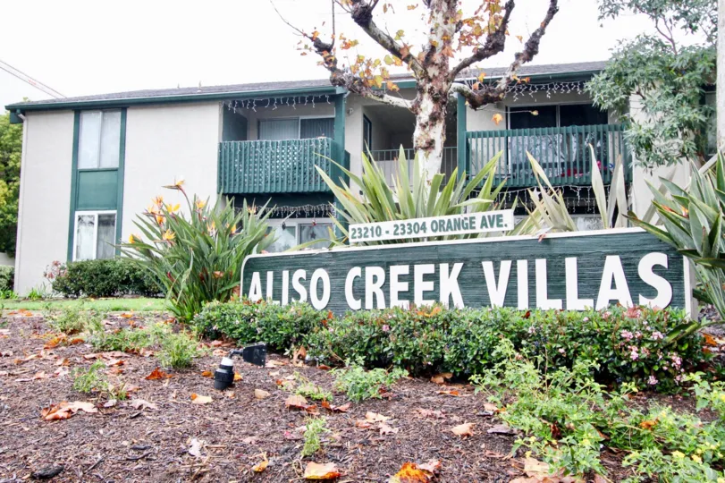 A sign is placed in a garden at Aliso Creek Villas.