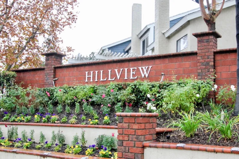 Two white brick chimneys sit high above townhomes in the Hillview community