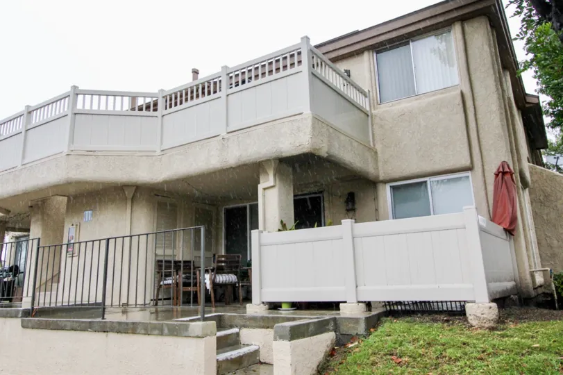 A SIGHT OF A HOUSE WITH THE CONTRAST OF CREAM & WHITE COLOR WITH SOME GREEN AREA ON A RAINY DAY