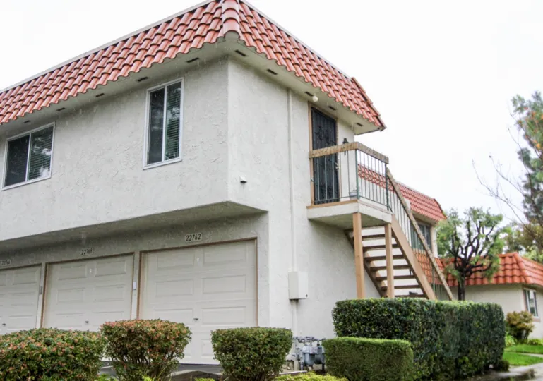 A white condos with red roof and stair case in Rancho Viejo Condos II community in Lake Forest, California.