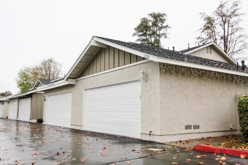Many garages with a wet ground with leaves on it in Richwood community in Lake forest, California.