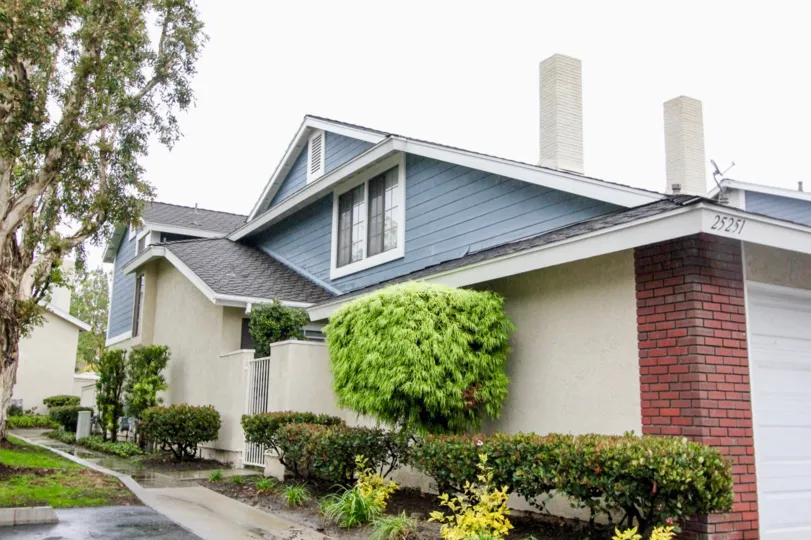 The wet cool pavement of the white and blue house of San Remo Villas, Lake Forest at California.