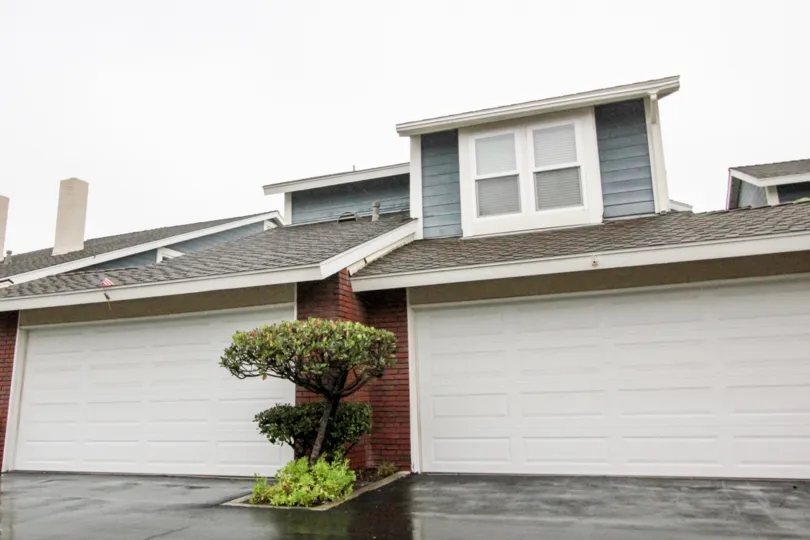 A SIGHT OF A BEAUTIFUL COTTAGE WITH THE CONTRAST OF GREY & WHITE COLOR & WITH THE FACILITY OF GARRAGE