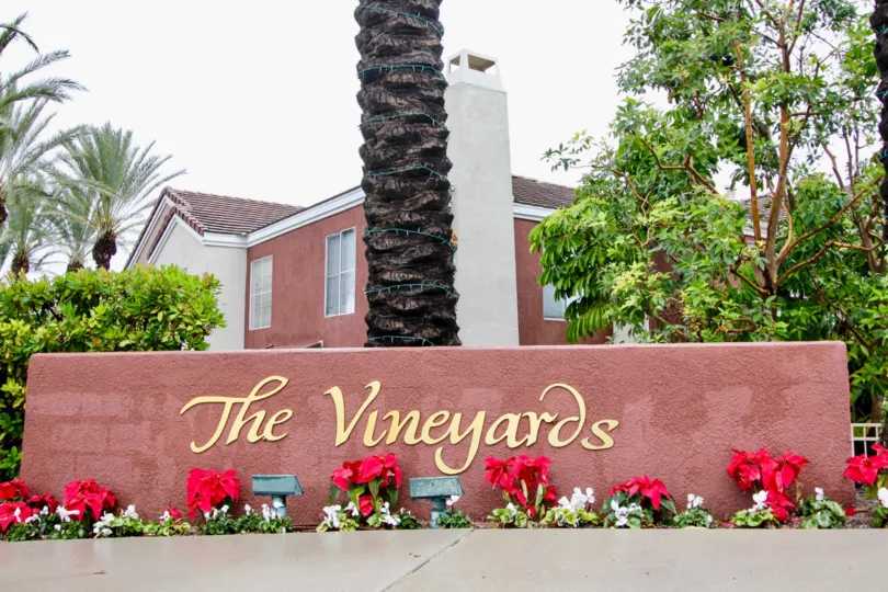 Flower and tree lined, festive entrance to The Vineyards in Lake Forest