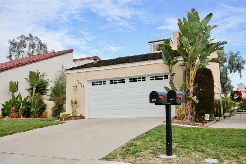 Front view of a residence located in Aegean Heights, California. Gated and two car garage.