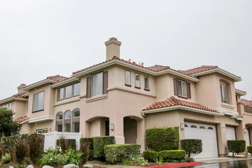 A very large tan home with bushes around it in California Terrace community in Mission Viejo, California.