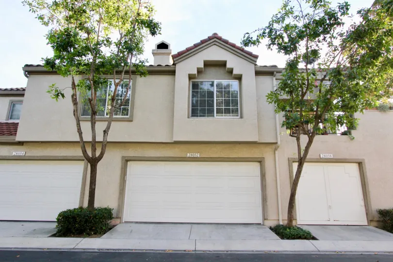 Shaded front of large house, garage and trees in Coral Gardens, Mission Viejo