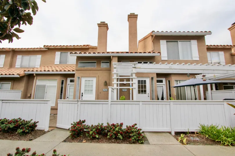 Outside view of condos and white privacy fence in Emerald Pointe I, Mission Viejo, California.