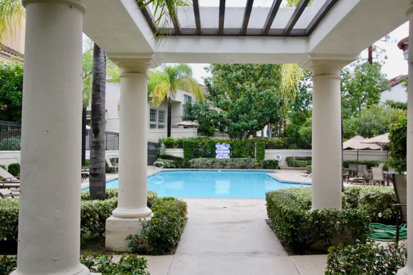 THE BUILDING IN THE GREYSTONE CALIFIA WITH THE SWIMMING POOL, CHAIRS, PLANTS, TREES