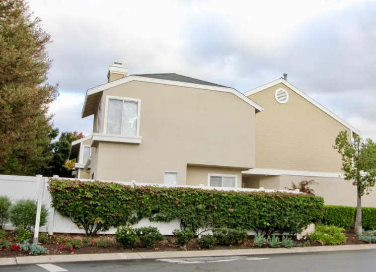 A SIGHT OF BEAUTIFUL HOUSE WITH THE CONTRAST OF PEACH & WHITE COLOR & SURROUNDED WITH WHITE FENCE