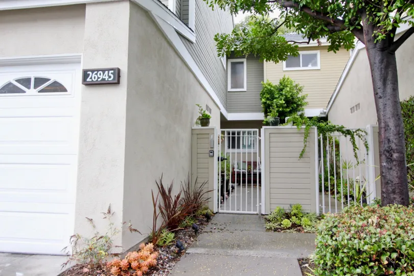 A small white gate in front of a building in the Highland Park.