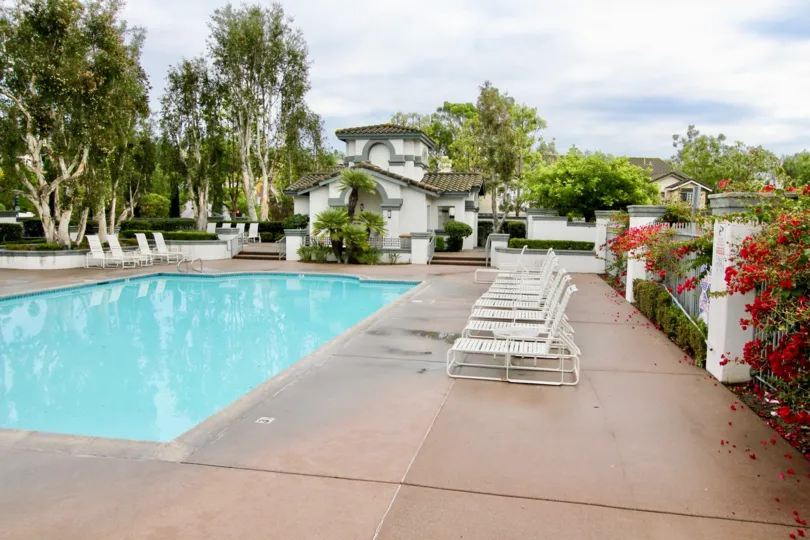 THE HOUSE IN THE MELROSE WITH THE SWIMMING POOL, CHAIRS, FLOWER PLANTS, TREES