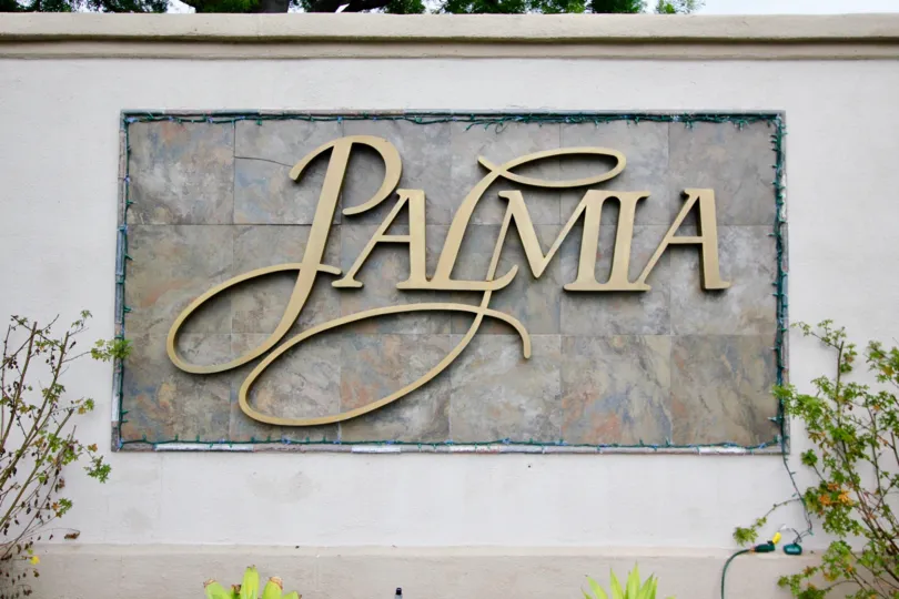 A view of a apartment complex called Palmia in Mission Viejo, California with some shrubbery next to it