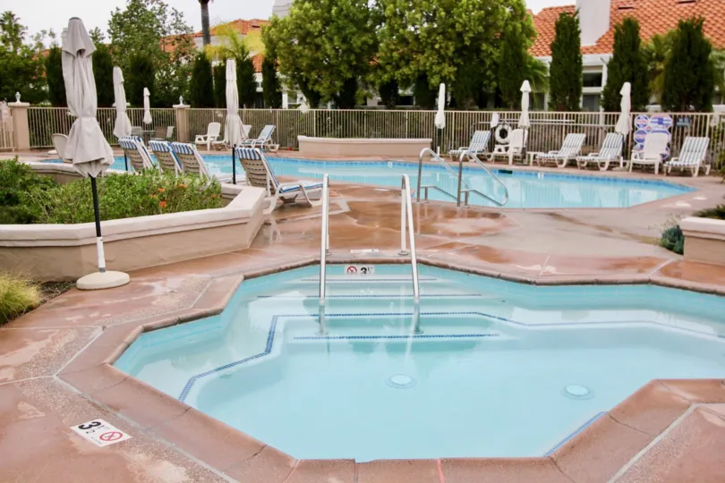 A blue color swimming pool in the Palmia Courts 1 nearby some trees.