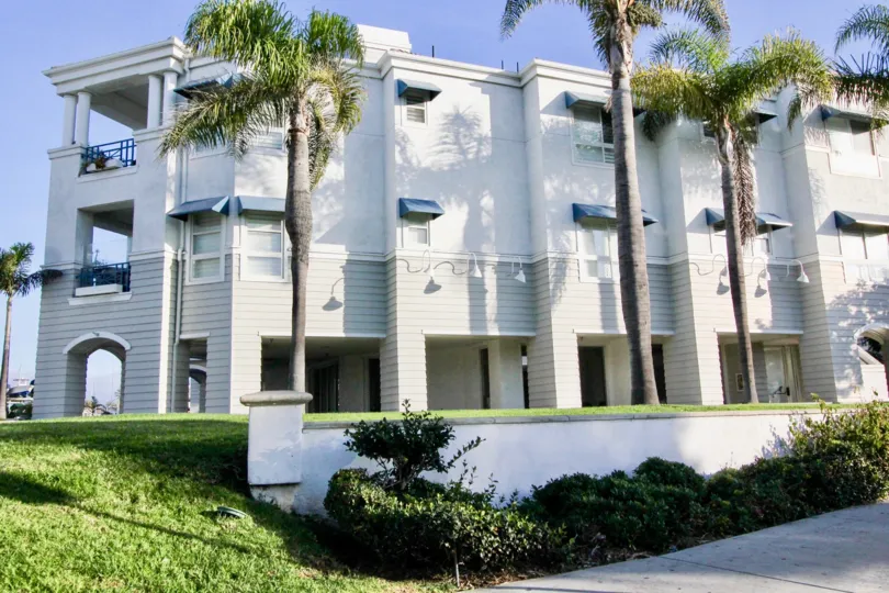 a warm day in the 28th street marina with building that has front of 3 trees & garden