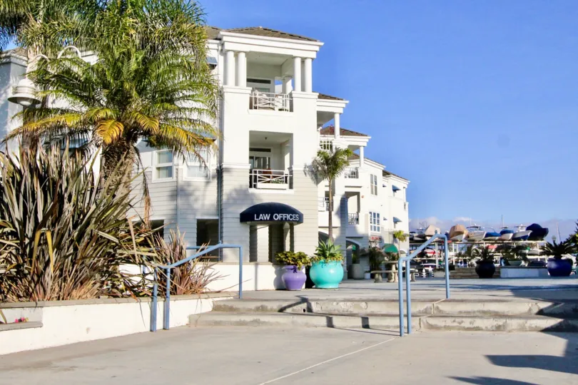 a sunny day in the 28th street marina with building that has name of law office of front in trees
