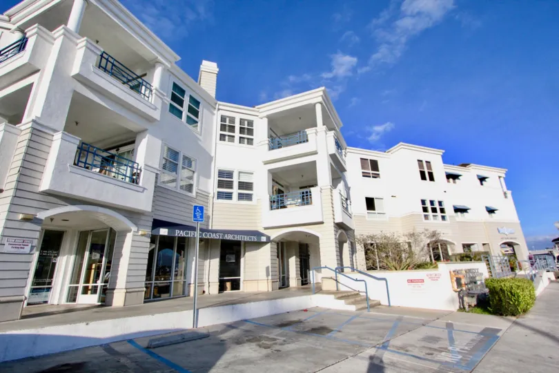 Sunny sky with apartments and parking spots in the 28th Street Marina Community in Newport Beach, CA.