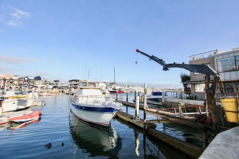 A small ship sits inside a marina at 28th Street Marina in Newport Beach CA