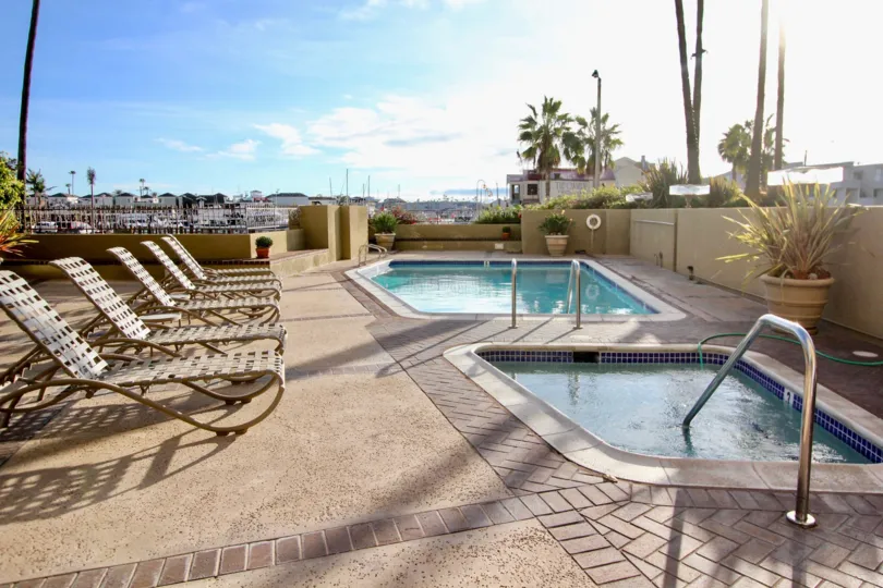 THIS IMAGE SHOWS THAT THE SWIMMING POOL IN THE LIDO PARK PLACE WITH THE CHAIRS, FLOWER POT