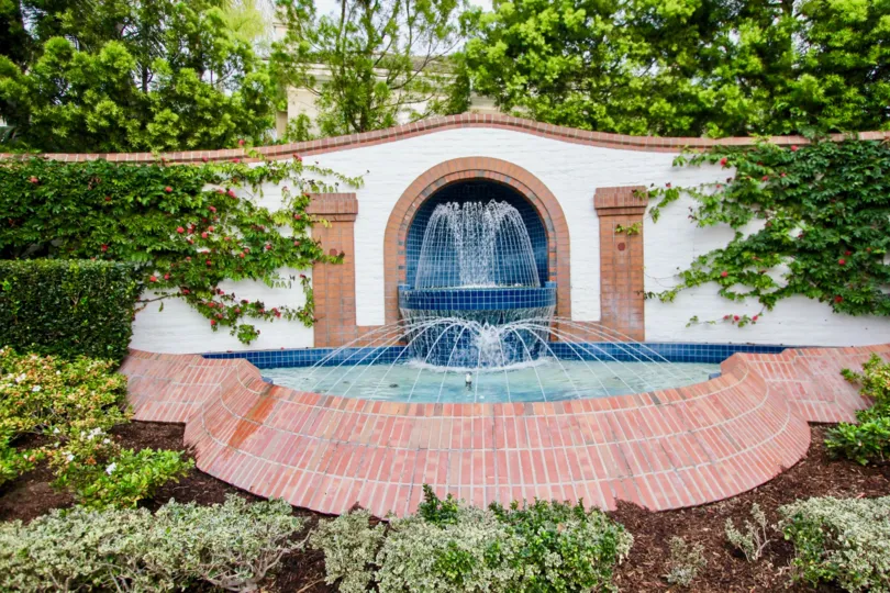 THE HOUSE IN THE BELCOURT TOWNE COLLECTION WITH THE WATER FALLS, PLANTS, TREES, FLOWERS