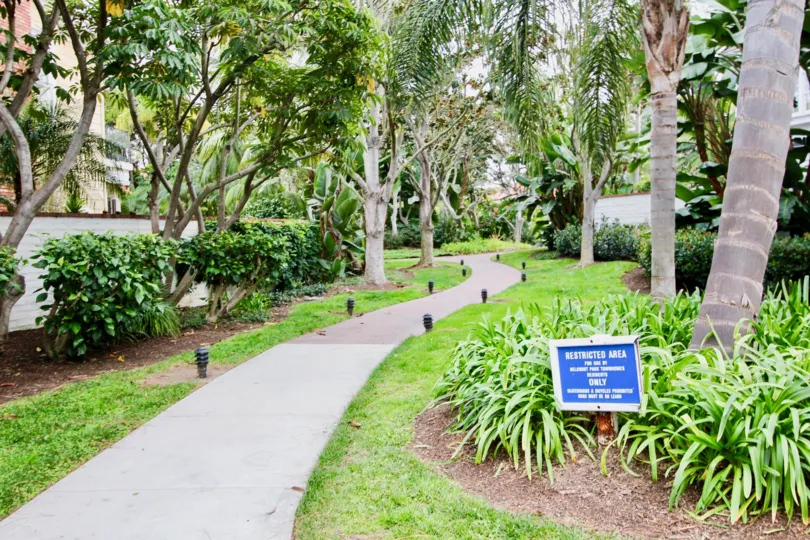 A small walkway leads through a landscaped area of the Belcourt Towne Collection community in Newport Beach, California.